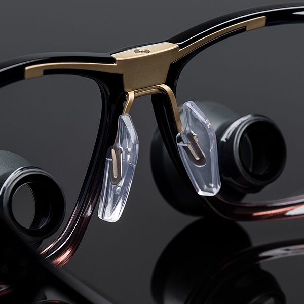 Dettaglio del ponte centrale in metallo delle loupes Univet Look & Cool Galilean per resistenza e design ergonomico